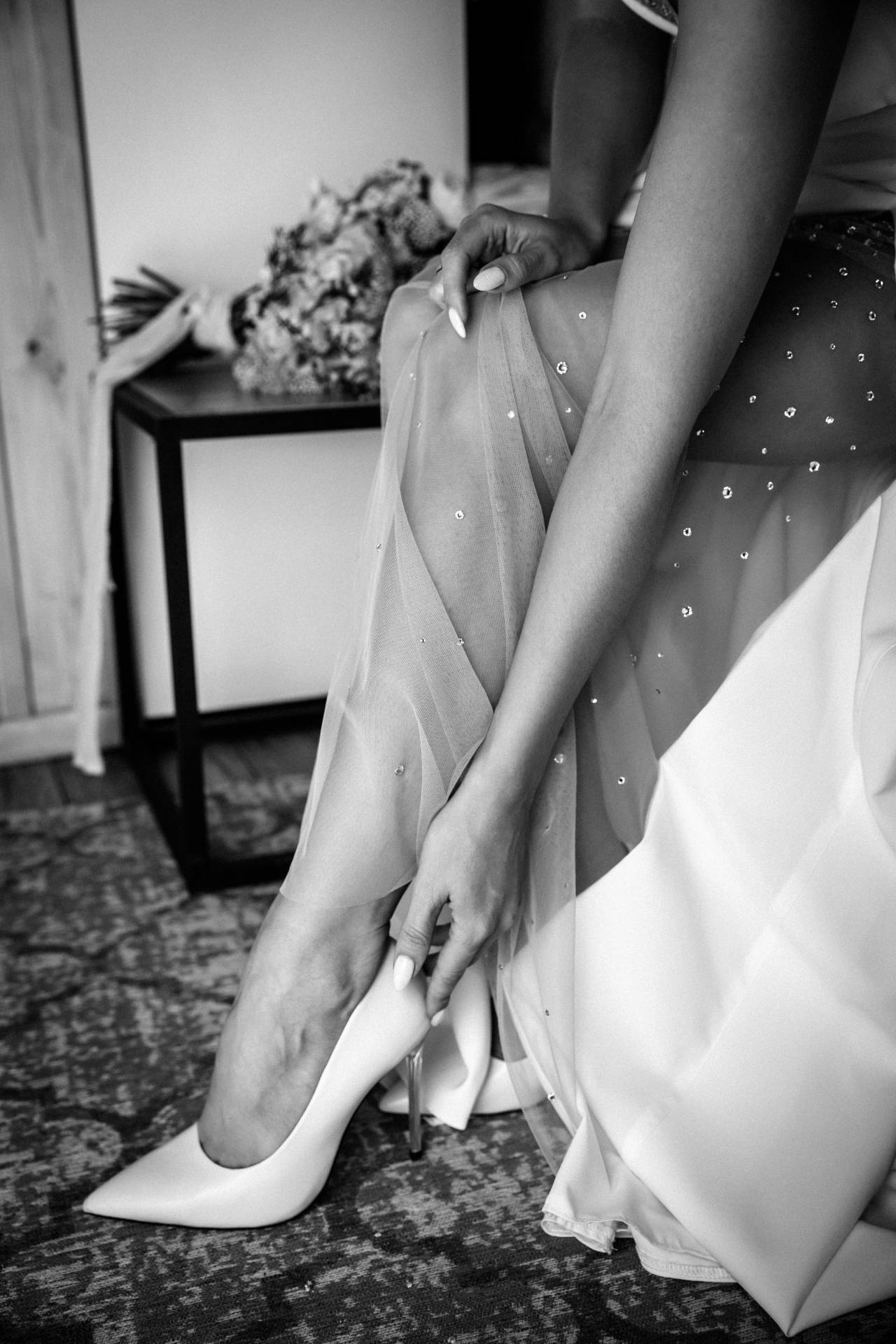 Hertfordshire Wedding Photographer - Shrigley Photography & Films - SHRIGLEY Bride putting on her shoes with wedding bouquet in background - Hertfordshire Wedding Photographer - Shrigley Photography & Films